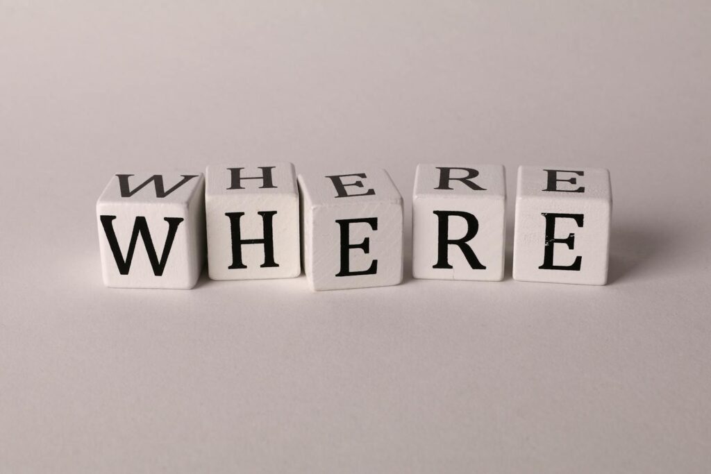 Close-up of white blocks with letters spelling 'WHERE' against a plain background.