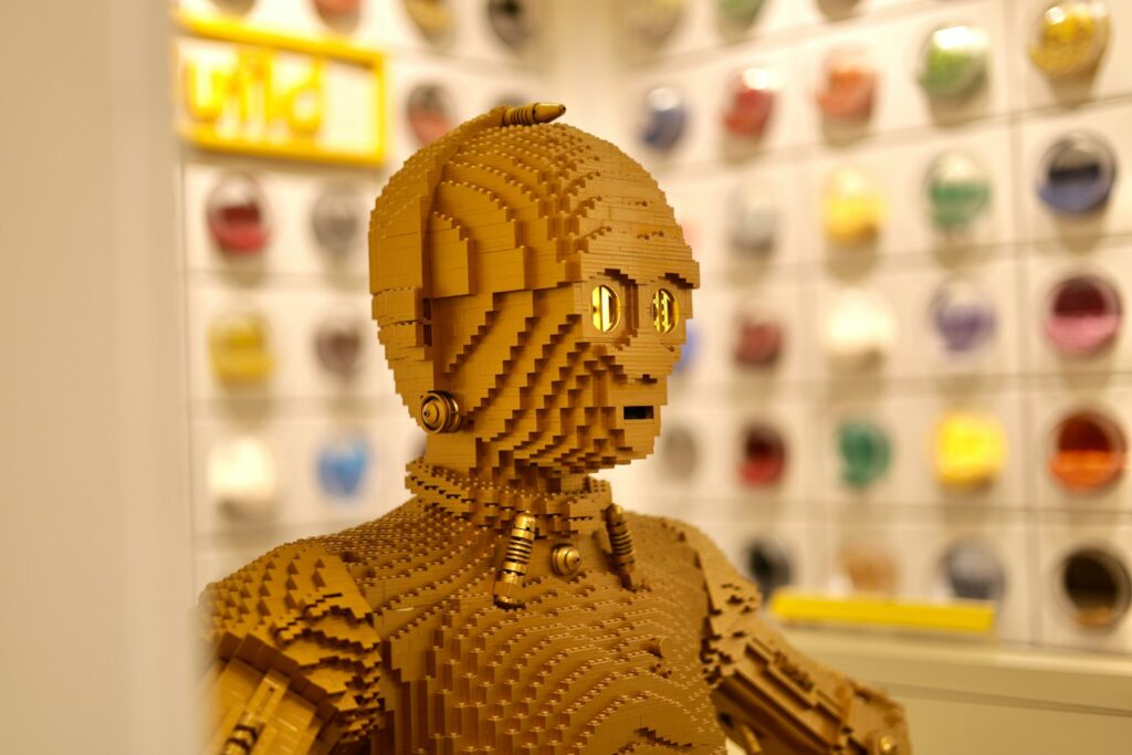 a lego robot is standing in front of a wall of buttons